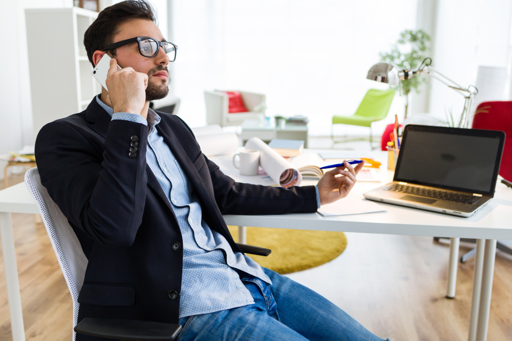 Immobilieninvestor bespricht Kapitalanlage telefonisch im Büro