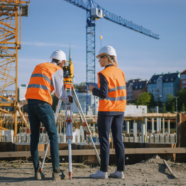 Bauleiter und Ingenieur besprechen Baufortschritt einer Kapitalanlageimmobilie