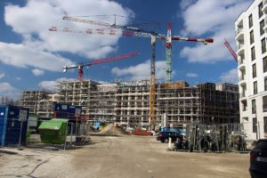 Mehrere Baukräne auf Baustelle einer Neubau-Wohnanlage