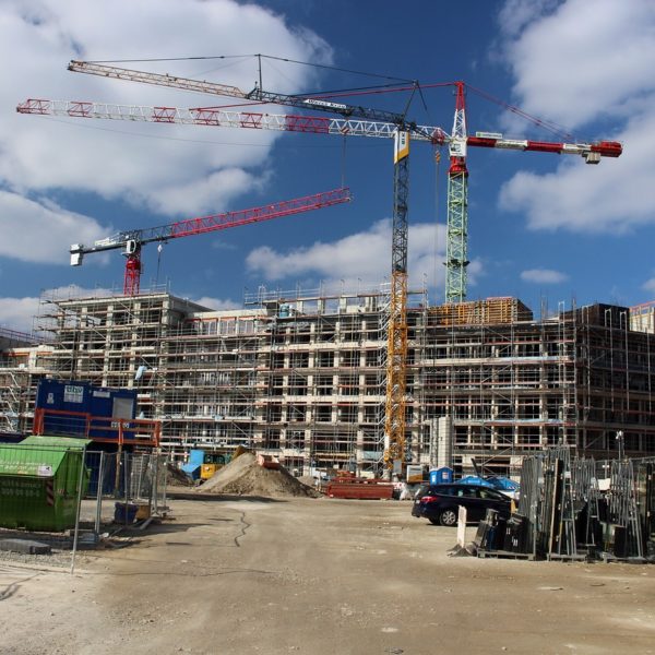 Mehrere Baukräne auf Baustelle einer Neubau-Wohnanlage